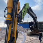 Drilling and Splitting Excavator Attachment for Controlled Rock Breaking Excavator drilling and splitting rock at a construction site
